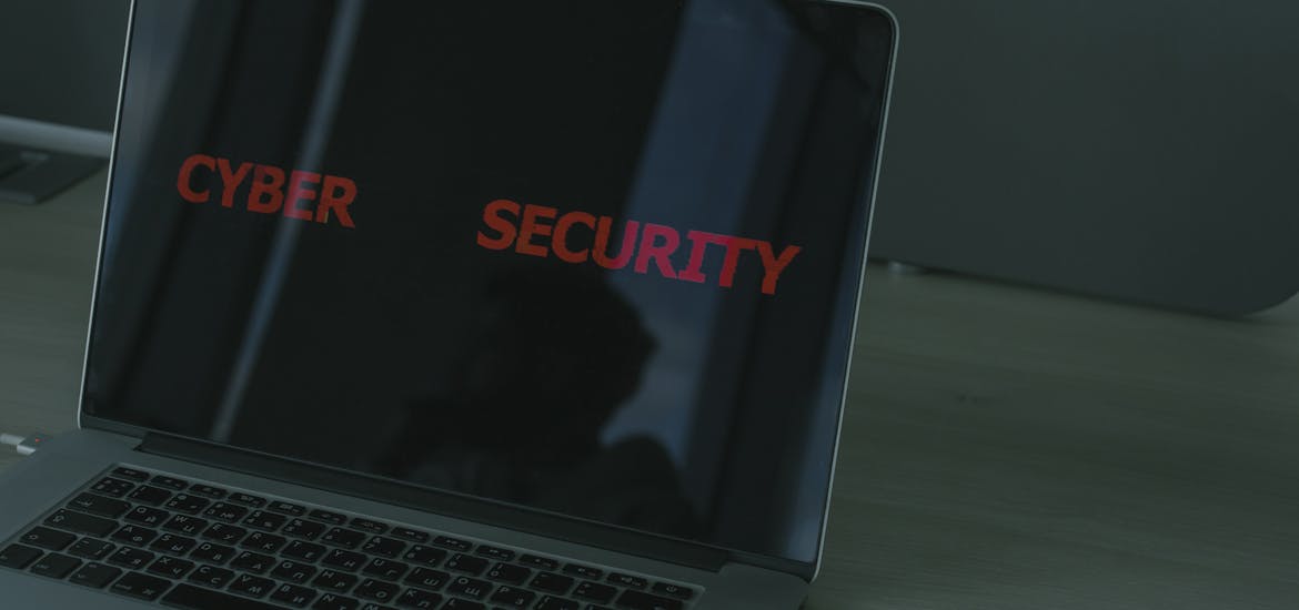 Close-up of a laptop displaying cybersecurity text, emphasizing digital security themes.